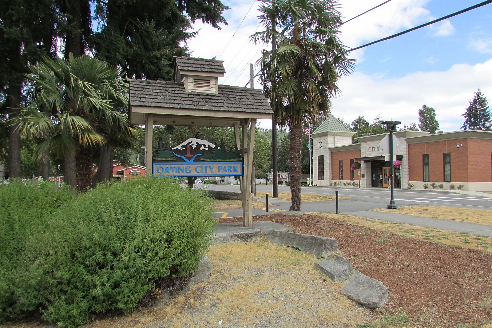 Main City Park entrance sign with City Hall behind
