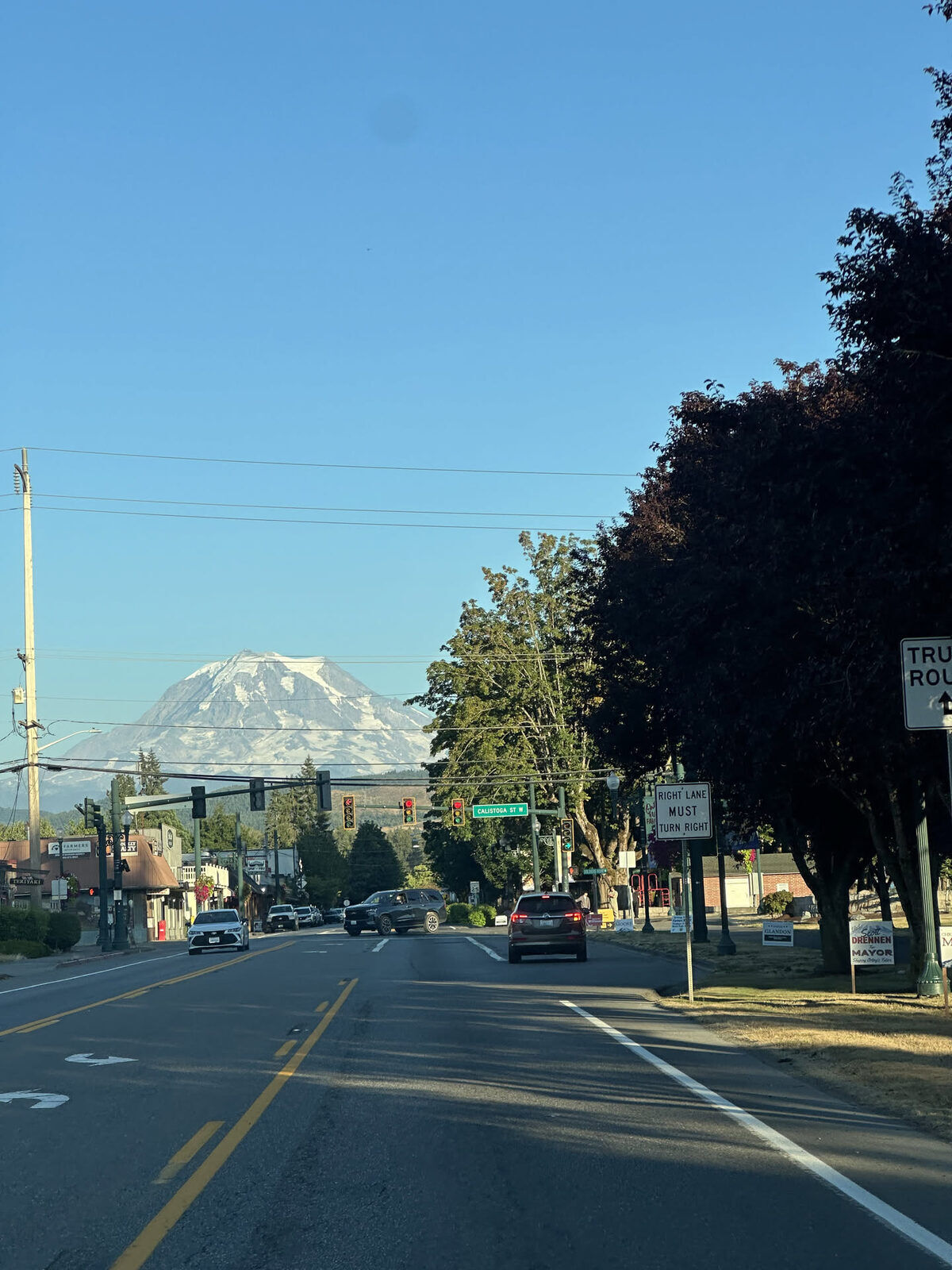 Mount Rainier rising above a downtown Orting street on a summer evening